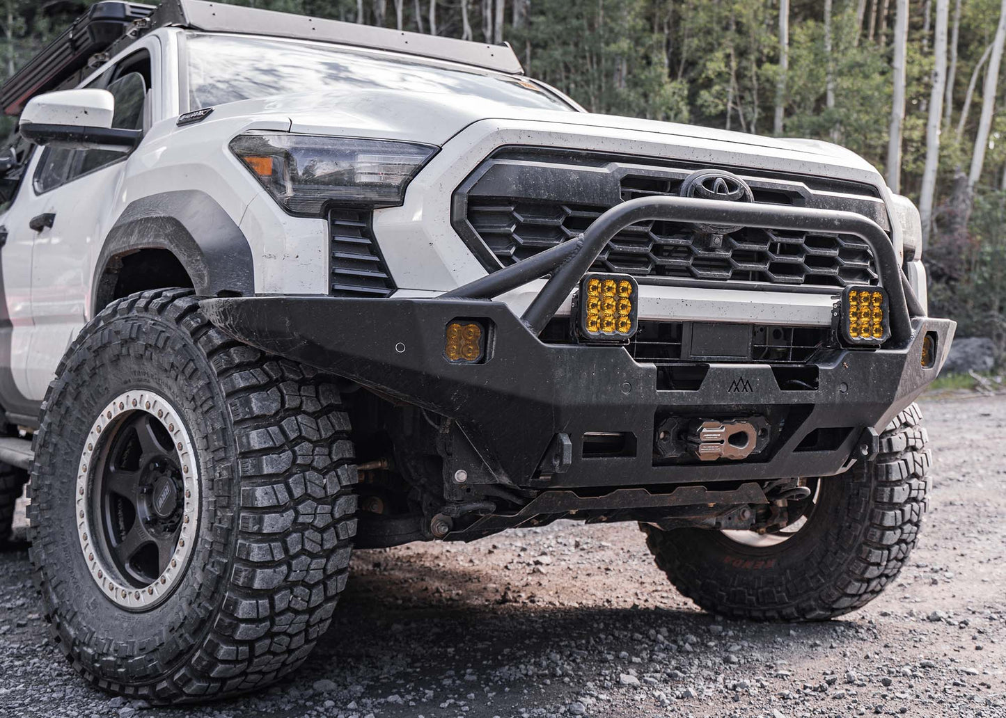 White 2024 4th Gen Toyota Tacoma with Backwoods Adventure Mods Hi-Lite Overland high clearance Front Bumper with Prerunner Bull Bar and winch installed