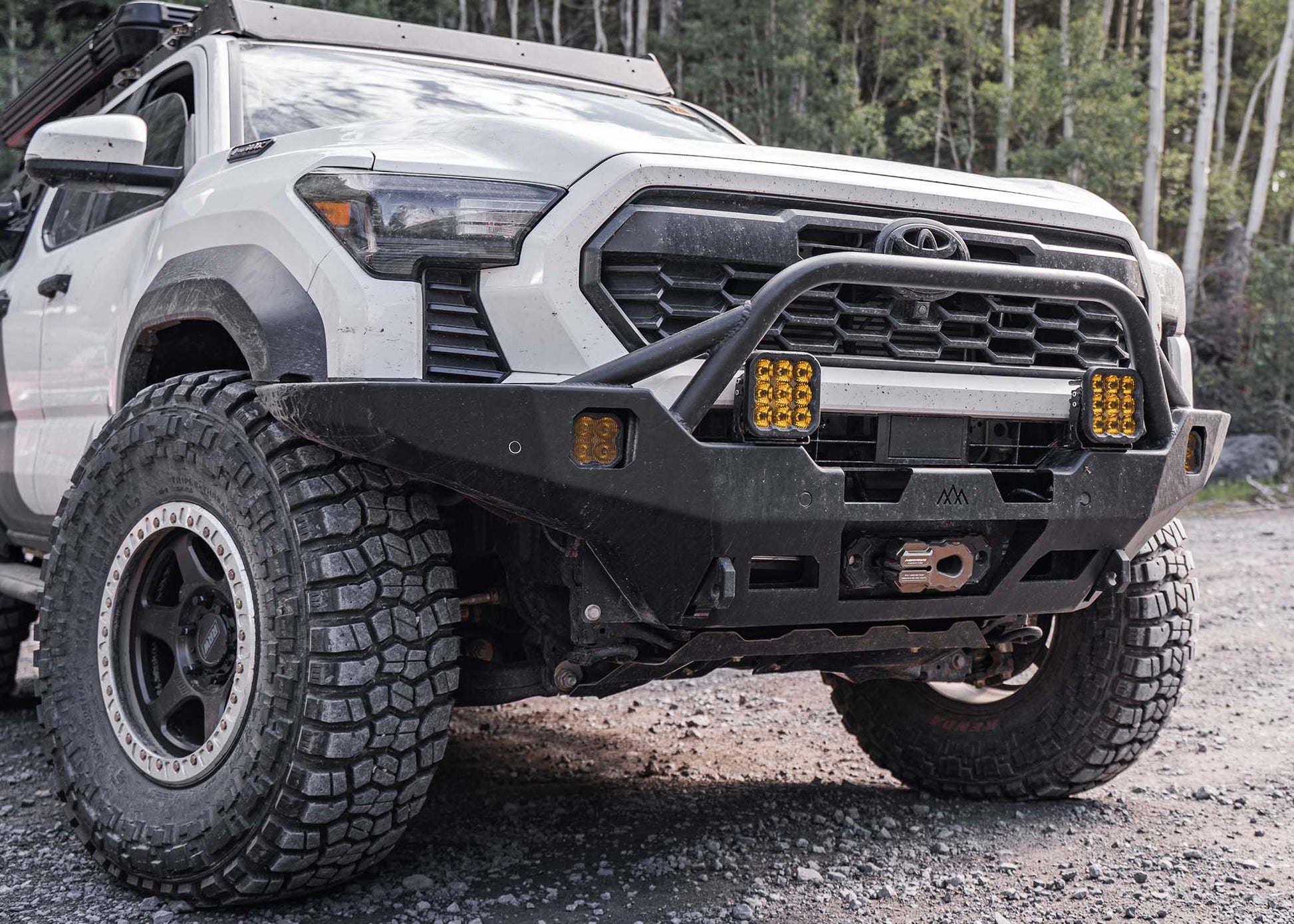 White 2024 4th Gen Toyota Tacoma with Backwoods Adventure Mods Hi-Lite Overland high clearance Front Bumper with Prerunner Bull Bar and winch installed