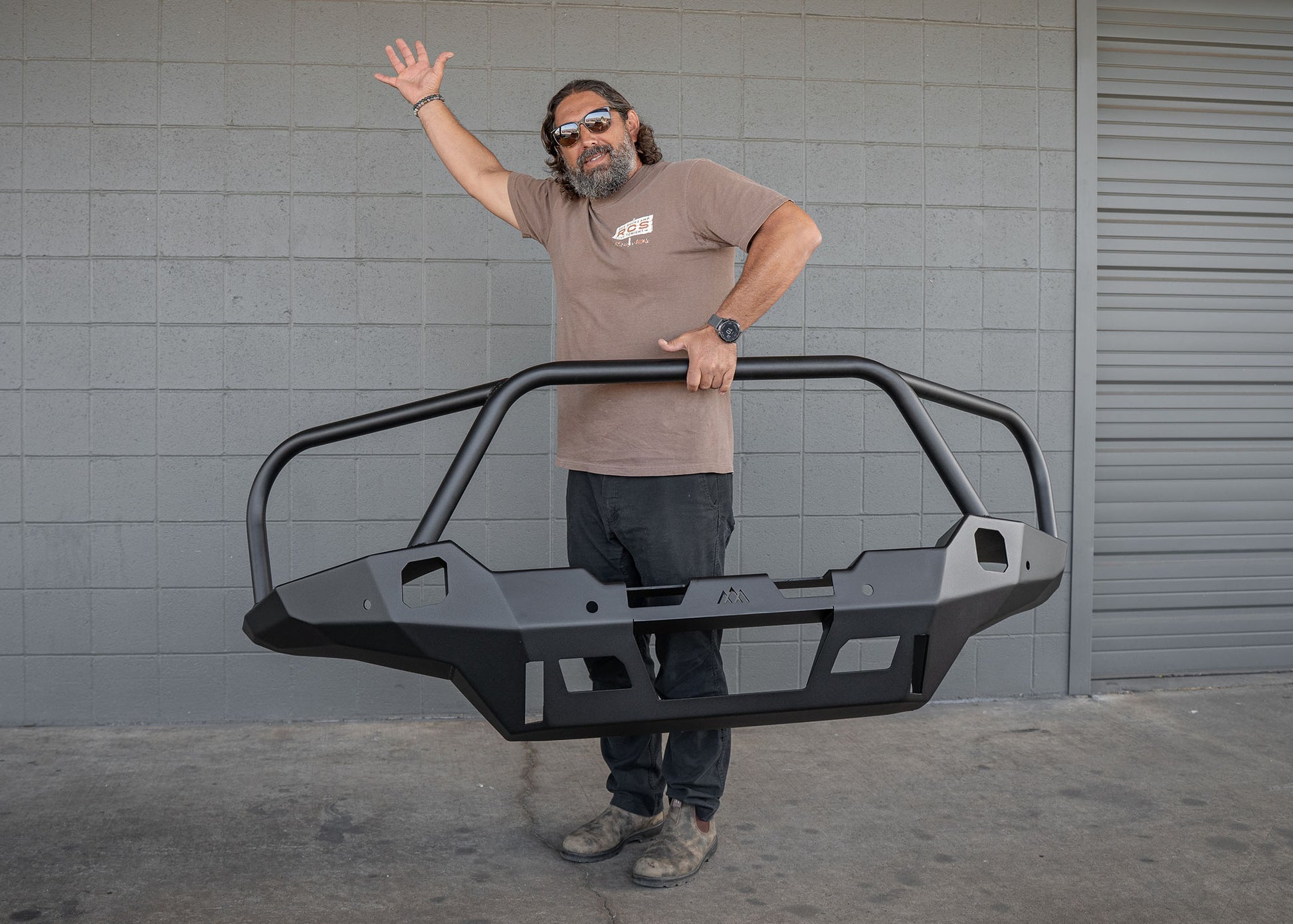 Man lifting the Backwoods Adventure Mods Toyota Tacoma 4th Gen (2024) Hi-Lite Front Bull Bar Bumper with one hand