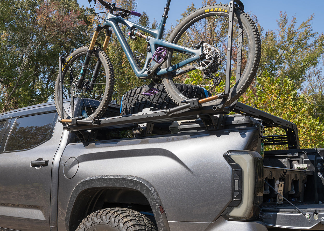 Bike tray mounted to a truck bed rack using Backwoods Adventure Mods Universal Bike Tray Mounts