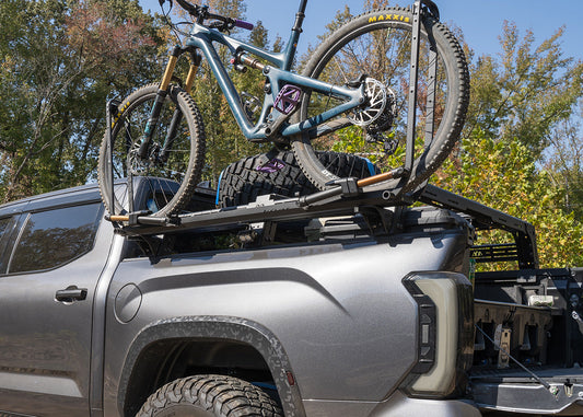 Bike tray mounted to a truck bed rack using Backwoods Adventure Mods Universal Bike Tray Mounts